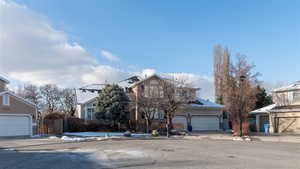 Traditional-style home with stucco siding, driveway, an attached garage, fence in a quiet cul-de-sac.