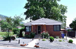 Bungalow-style home featuring brick siding and a xeriscaped yard