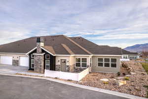 View of front facade with private patio and 2 car garage
