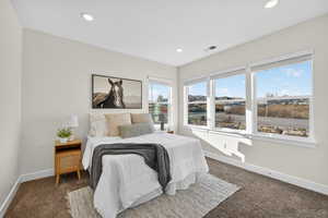Bedroom with dark carpet and recessed lighting