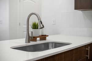 Kitchen featuring a stainless-steel appliances, quartz counter and tile backsplash