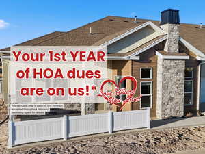 Exterior view of stone siding, a shingled roof, and a downspout