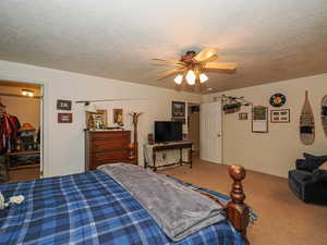 Carpeted bedroom featuring baseboards, a textured ceiling, and ceiling fan