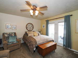 Carpeted bedroom with a ceiling fan, baseboards, visible vents, access to exterior, and a textured ceiling