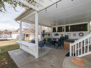 View of patio / terrace with an outdoor hangout area, a trampoline, a ceiling fan, and fence