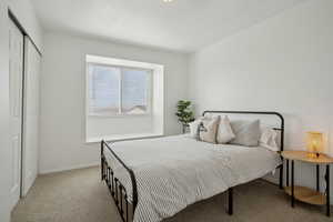 Carpeted bedroom featuring a closet and baseboards