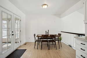 Dining room with light wood-style flooring, french doors, visible vents, and plenty of natural light