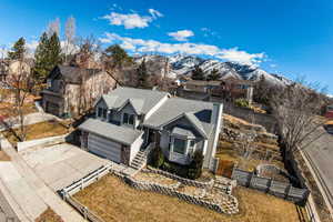View of front of house featuring a fenced front yard, roof with shingles, a mountain view, a garage, and driveway