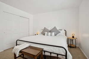 Carpeted bedroom with a closet and baseboards