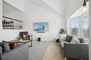 Living room with high vaulted ceiling, hardwood / wood-style flooring, and a wealth of natural light