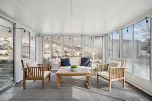 Sunroom featuring an outdoor living space and stone finish flooring