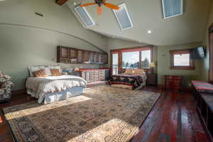 Bedroom featuring dark wood-style flooring, high vaulted ceiling, a skylight, beamed ceiling, and ceiling fan