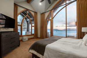 Bedroom with a water view, access to exterior, carpet flooring, and a ceiling fan
