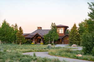 Log-style house with stone siding, a standing seam roof, and a metal roof