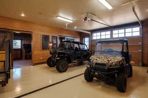 Garage featuring a garage door opener and wooden walls