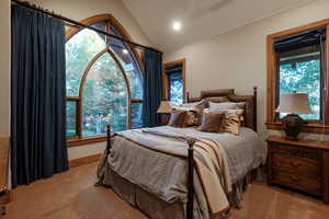 Bedroom with carpet flooring and lofted ceiling
