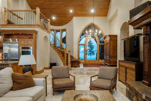 Living room featuring stairway, high vaulted ceiling, wooden ceiling, a chandelier, and recessed lighting