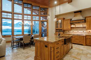 Kitchen with brown cabinets, high vaulted ceiling, wood ceiling, a water and mountain view, and light stone counters