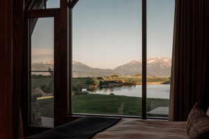 Bedroom with a water and mountain view and multiple windows