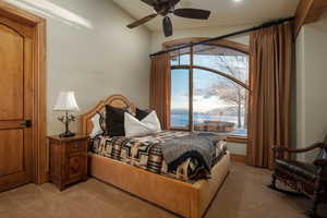Carpeted bedroom featuring a water view and ceiling fan