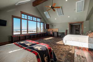 Bedroom with beam ceiling, wood-type flooring, a skylight, high vaulted ceiling, and recessed lighting