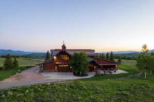 Exterior space featuring driveway, a mountain view, a lawn, board and batten siding, and a garage