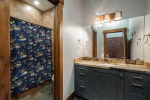Full bath with a shower with shower curtain and vanity