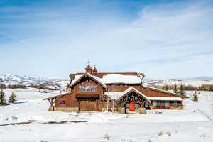 View of front of house featuring board and batten siding and stone siding
