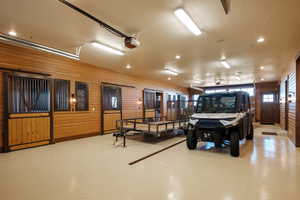 Garage with a garage door opener, recessed lighting, and wood walls