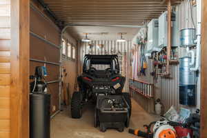 Garage featuring a central vacuum unit and tankless water heater