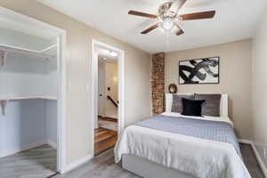 Bedroom featuring a ceiling fan, wood finished floors, and baseboards