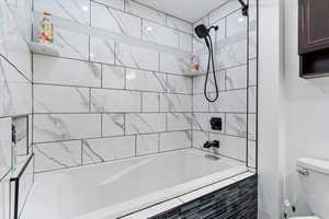 Bathroom featuring toilet and tiled shower / bath