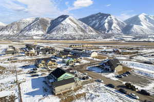 Snowy aerial view featuring a residential view and a mountain view