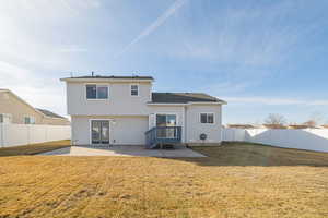 Rear view of property with a patio, a lawn, and a fenced backyard