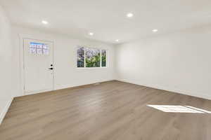 Foyer with recessed lighting, wood finished floors, and baseboards