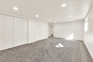 Unfurnished bedroom with baseboards, recessed lighting, two closets, and carpet