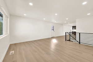 Spare room featuring light wood-type flooring, visible vents, baseboards, and recessed lighting