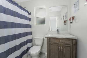 Ensuite Bathroom with a shower with curtain, baseboards, toilet, and vanity