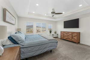 Bedroom featuring baseboards, carpet, recessed lighting, a raised ceiling, and a ceiling fan