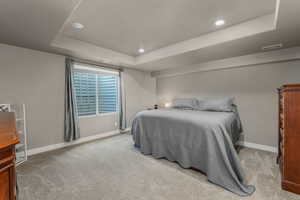 ADU Carpeted bedroom featuring recessed lighting, visible vents, a raised ceiling, and baseboards