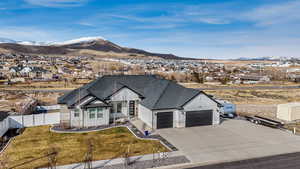 View of front of home with board and batten siding, a garage, fence, and a mountain view