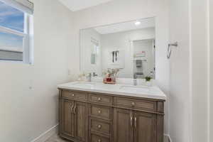 Bathroom featuring a sink, a healthy amount of sunlight, and double vanity