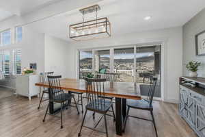 Dining area featuring baseboards, light wood-style floors, an inviting chandelier, and wooden walls