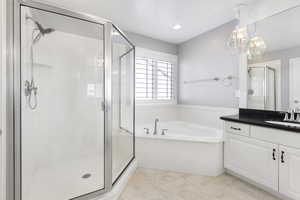 Full bath with vanity, a garden tub, and a stall shower