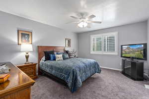 Carpeted bedroom with a ceiling fan, walk-in closet, and on-suite with separate jetted soaking tub, oversized shower and double sink vanity