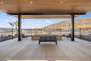 View of patio / terrace with a mountain view, a fenced backyard, and an outdoor fire pit