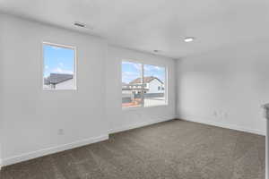 Unfurnished room featuring baseboards, visible vents, and carpet floors