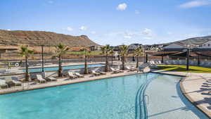 Pool with a mountain view, a patio, and fence