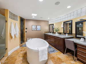 Primary bathroom with soaking tub, steam shower w/ bench, dual sink vanity & stackable washer and dryer.