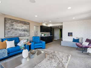 Living room with wet bar and tile wall with steam fireplace and quartz hearth